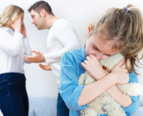Forældre der skændes mens barn krammer sin bamse- skilsmisse og børn